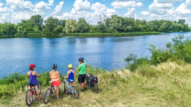 Familia en bicicletas ciclismo al aire libre padres e hijos activos en bicicletas vista aérea de familia feliz