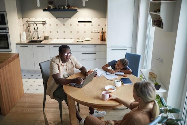 Familia birracial en ángulo alto de mesa