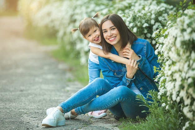 Família bonita ao ar livre. jovem mãe bonita com sua filha pequena