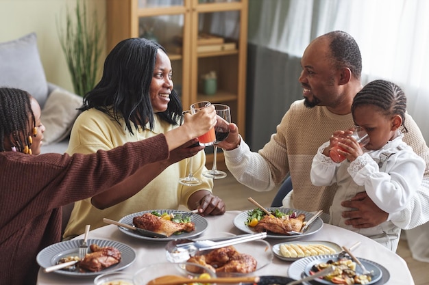 Familia brindando con bebidas en la mesa