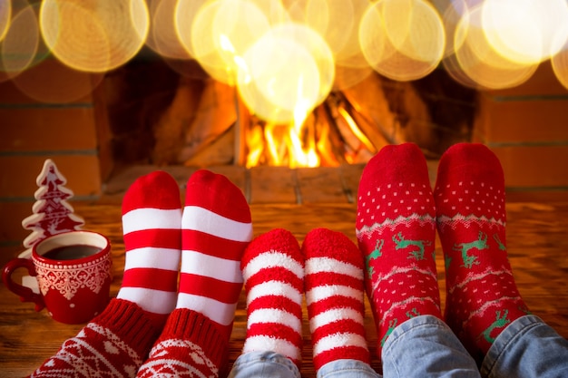 Familia en calcetines de Navidad junto a la chimenea
