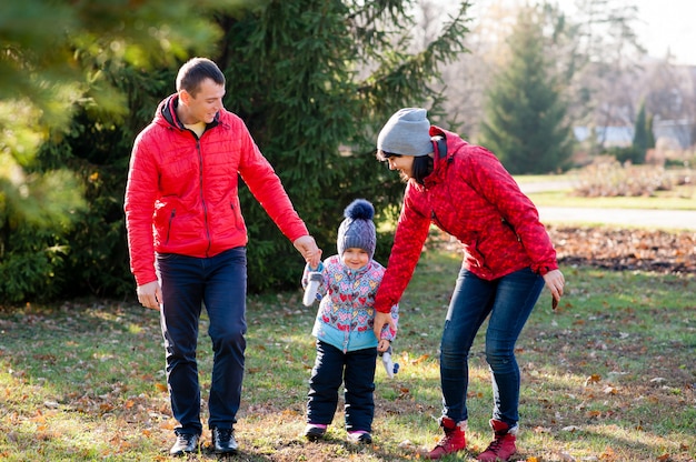 La familia camina en el parque en otoño