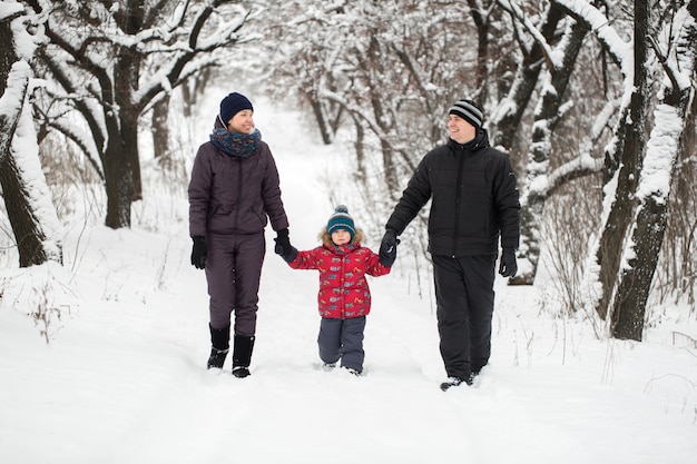 Familia caminando por el bosque nevado