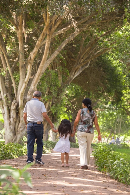 Familia caminando por el parque en un brillante día de verano