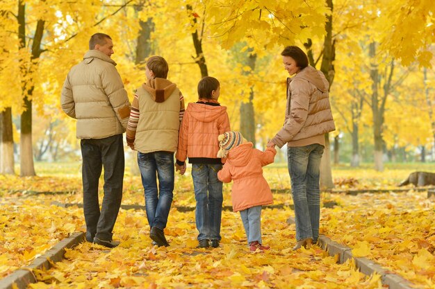 Familia caminando en el parque otoñal