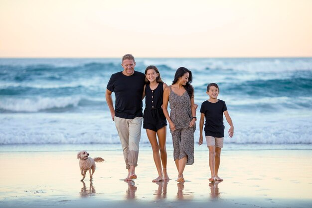 Foto una familia está caminando por la playa con el océano en el fondo