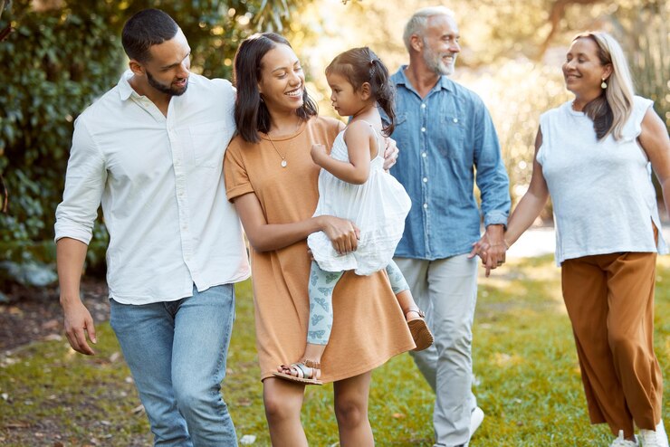 Foto família caminhando e juntos no parque com amor e passando tempo de qualidade ao ar livre para criar vínculos e cuidar dos avós, pais e filhos caminham felizes na natureza e gerações familiares felizes
