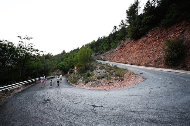 Família caminhando na estrada de montanha giratória da cidade de Nocera Umbra e comuna na província de Perugia, Itália