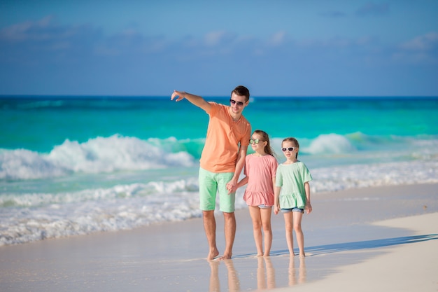 Família caminhando na praia tropical branca na ilha do Caribe