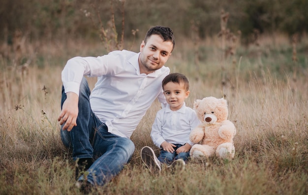 Una familia se para en un campo y besa a sus padres.