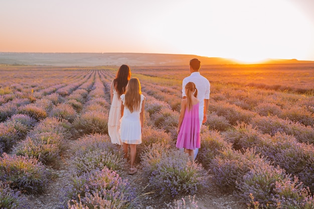 Familia en campo de flores de lavanda al amanecer