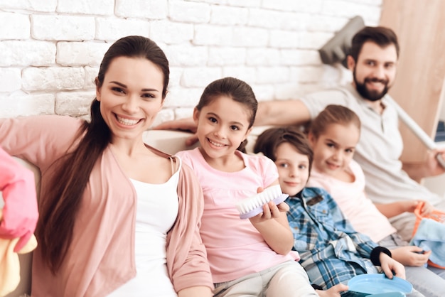 Família cansada de limpeza está sentado no sofá no apartamento.