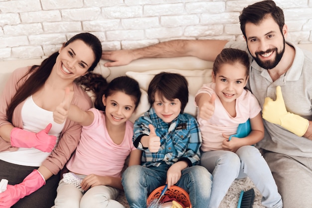 Familia cansada de la limpieza está sentado en el sofá del apartamento.