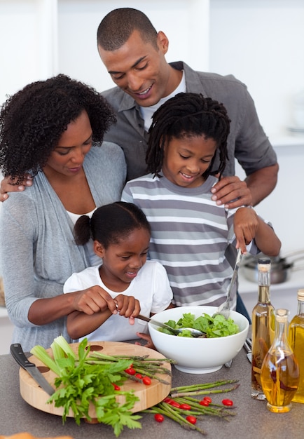 Família carinhosa preparando salada juntos