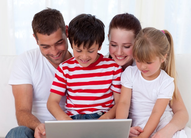 Familia en casa usando una computadora portátil