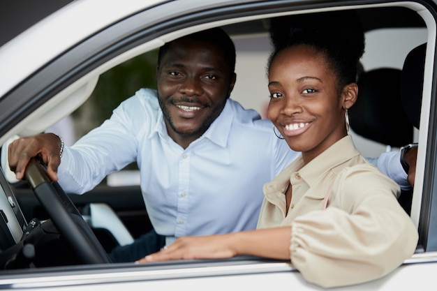 Familia casada negra examinando el coche desde el interior