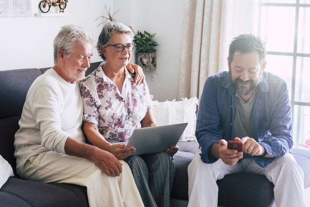 Família caucasiana em casa usando dispositivo de tecnologia moderna como telefone e laptop juntos se divertindo