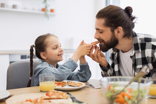 Familia caucásica disfrutando juntos de una pizza de desayuno en un hogar acogedor