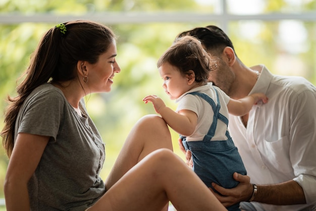 Familia caucásica del padre y de la madre con la gente pequeña del bebé, los niños lindos o la infancia de la niña recién nacida feliz juntos en casa con el amor, la mujer y la familia de la pareja del hombre