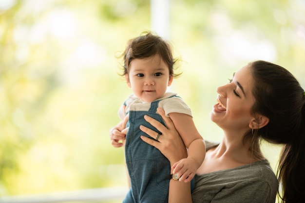 Familia caucásica del padre y de la madre con la gente pequeña del bebé, los niños lindos o la infancia de la niña recién nacida feliz juntos en casa con el amor, la mujer y la familia de la pareja del hombre