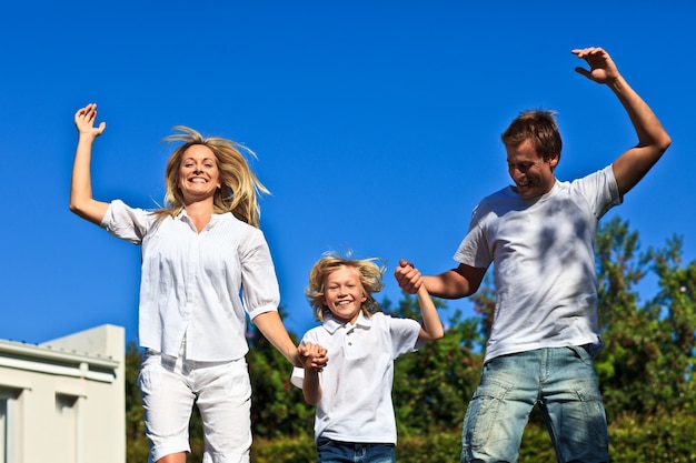 Familia caucásica positiva jugando en el jardín