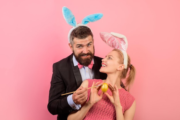 Familia celebra el día de Pascua. Pareja feliz. Felices vacaciones en familia. Pareja pintando huevos de Pascua. Ideas para decorar huevos. Vacaciones. Vacaciones de primavera. Temporada. Orejas de conejo. Hombre con orejas de conejo.