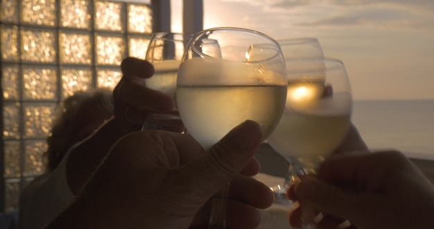 Familia celebra levantando sus copas de vino blanco en la ciudad de perea grecia