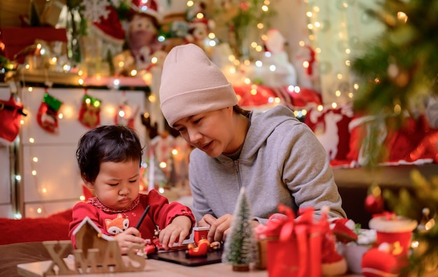 Familia celebra Navidad y feliz año nuevo en casa. Estilo de vida de mamá y niño en las vacaciones de fin de año.