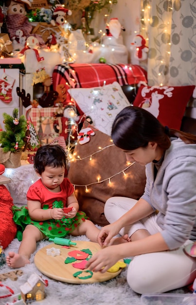 Familia celebra Navidad y feliz año nuevo en casa. Estilo de vida de mamá y niño en las vacaciones de fin de año.