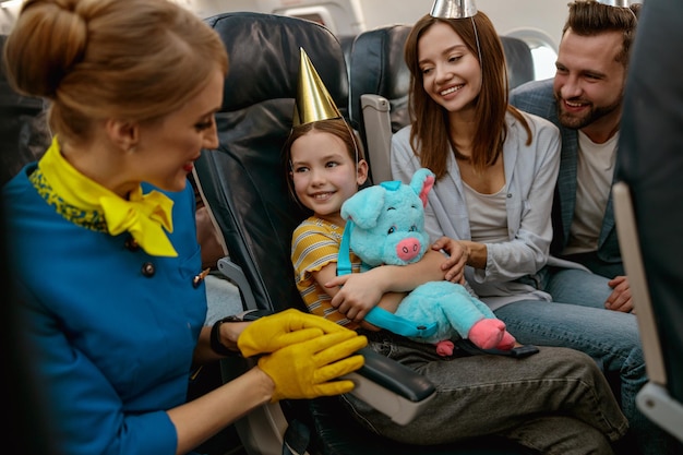 Familia celebrando el cumpleaños de un niño y hablando con la azafata en el avión