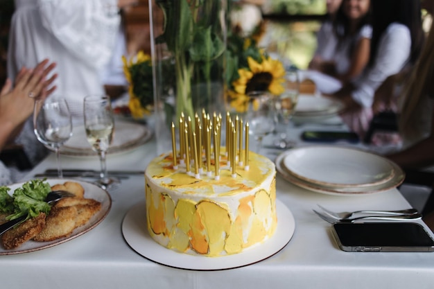 Familia celebrando feliz cumpleaños en la terraza de verano hermoso fondo de pastel de cumpleaños amarillo de