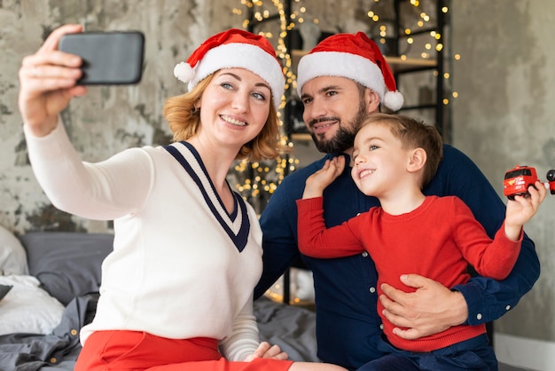 Foto familia celebrando la navidad junto con un selfie