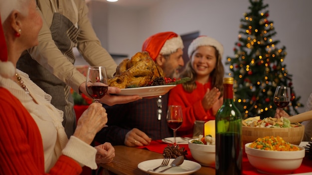 Familia celebrando la navidad juntos comiendo comida especial en el comedor