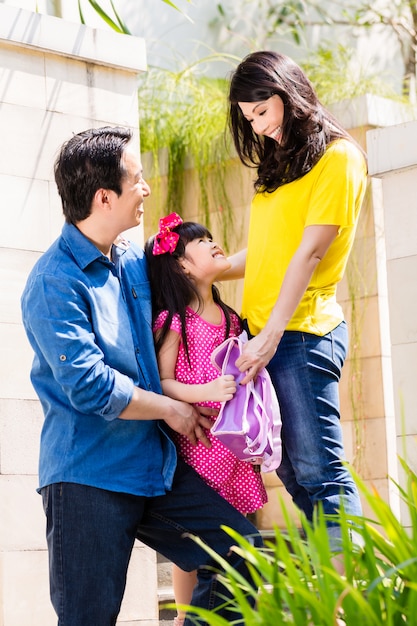 Familia china enviando niña a la escuela