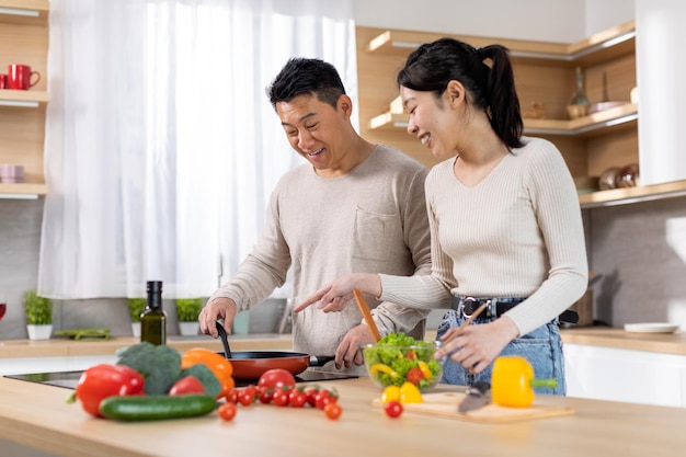 Familia china positiva haciendo comida en casa