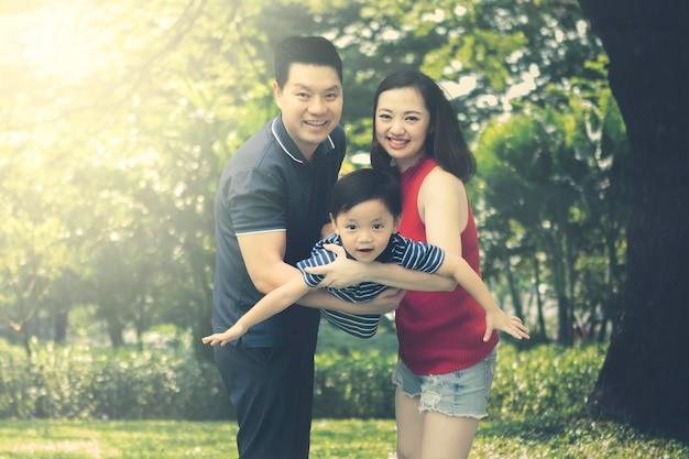 Família chinesa balançando seu filho