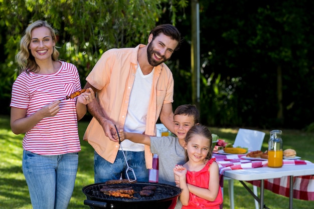 Familia cocinando comida en parrilla en el patio