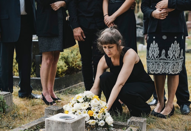 Família colocando flores no túmulo