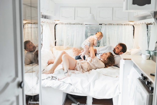 Família com bebê na cama no trailer pela manhã
