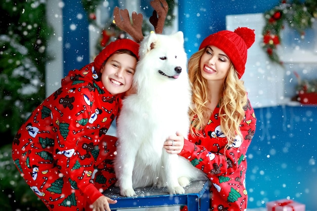 Família com clima de Natal Feliz e um animal de estimação em fantasias de Natal