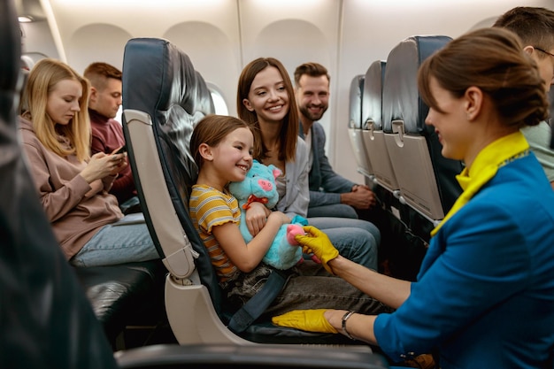 Família com criança conversando com aeromoça no avião