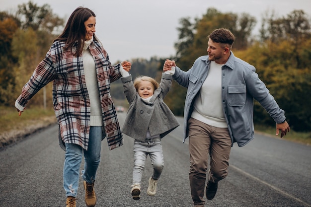 Foto família com filha pequena no clima de outono se divertindo