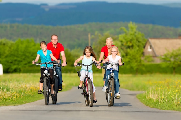 Família com filhos, andar de bicicleta no verão com bicicletas