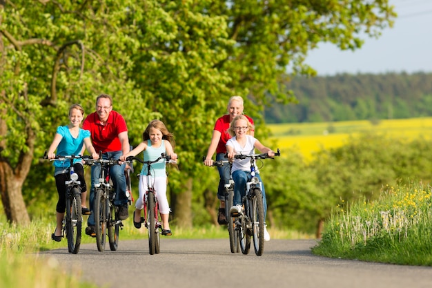 Família com filhos, andar de bicicleta no verão com bicicletas