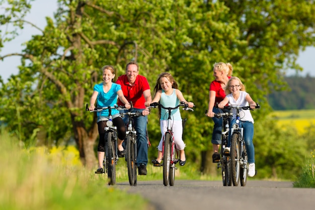 Família com filhos, andar de bicicleta no verão com bicicletas