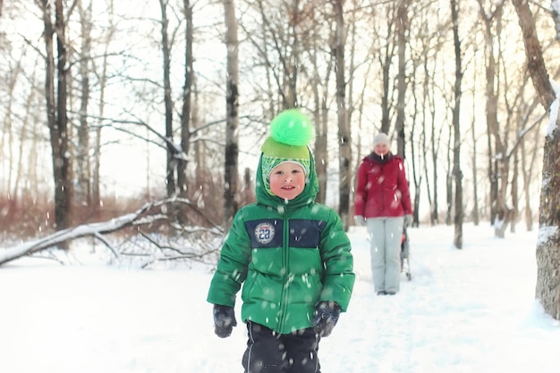 Família com filhos no parque durante nevasca de inverno