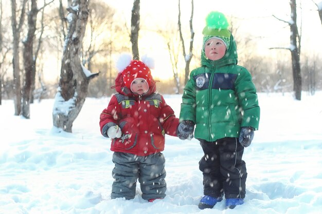 Família com filhos no parque durante nevasca de inverno