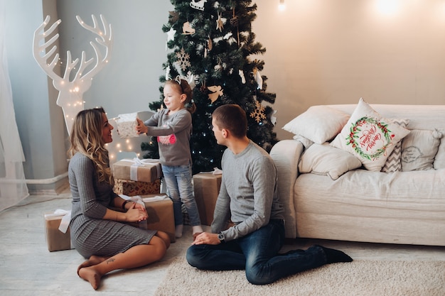 Família com presentes para o natal. árvore de natal.