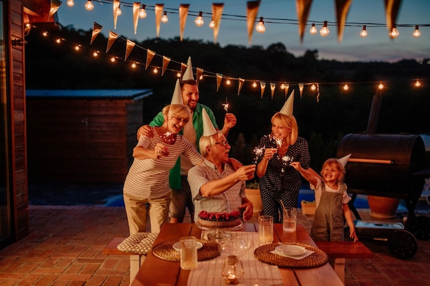 Família comemorando aniversário no quintal durante uma linda noite de verão