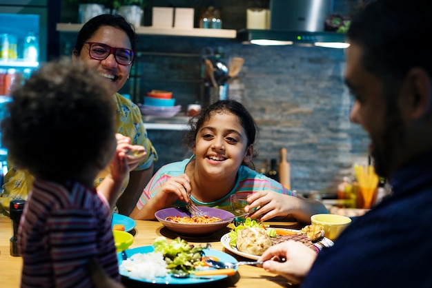 Família comendo na mesa de jantar juntos